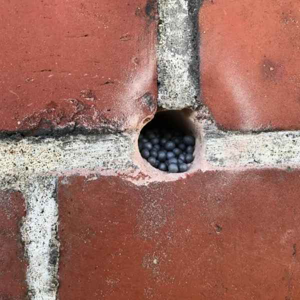 Bohrloch in der Klinker T-Fuge mit Dämmstoff gefüllt.