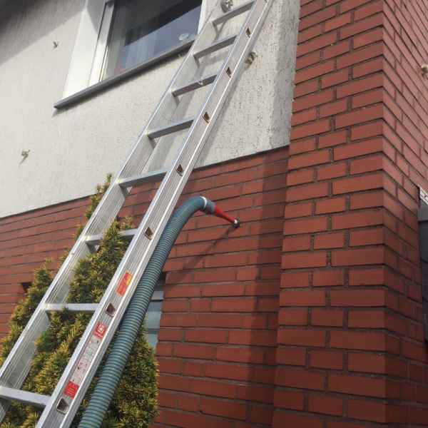 Verfüllung einer Außenwand mit Glaswolle.