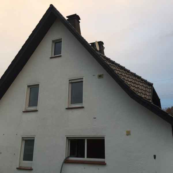 Verfüllen einer Außenwand mit Knauf Supafil Einblasdämmstoff.