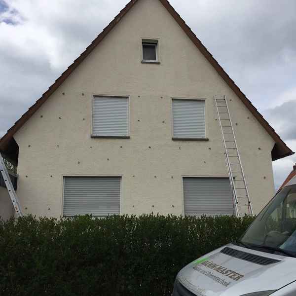 Bohrlöcher in einer Außenwand für die Einblasdämmung.