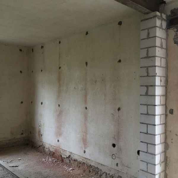 Eine Trennwand mit Luftschicht wird mit Steinwolle WLG 039 fertig ausgeblasen.