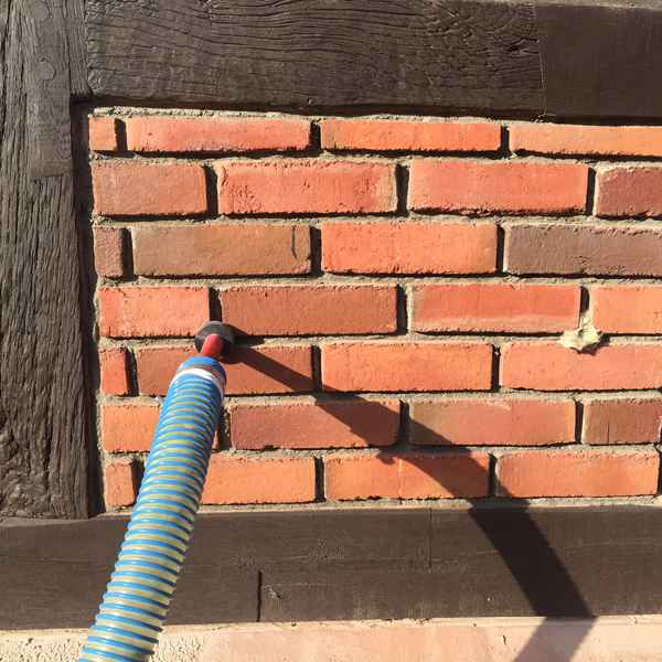 Durch eine Bohrung von außen wird der Dämmstoff in den Hohlraum eingeblasen.