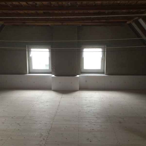 Fertig gestellte, begehbare Oberste Geschossdecke mit Zellulose-Dämmstoff gedämmt und mit Brettern geschalt.